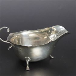 Group of early 20th century silver, comprising sauce boat, with flying scroll handle and upon three pad feet, two small cream jugs and a christening mug, all hallmarked, tallest H10cm