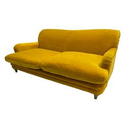 Loaf - large two seat 'Jonesy' sofa, upholstered in mustard velvet fabric with sprung back and loose seat cushions, raised on pale oak turned supports