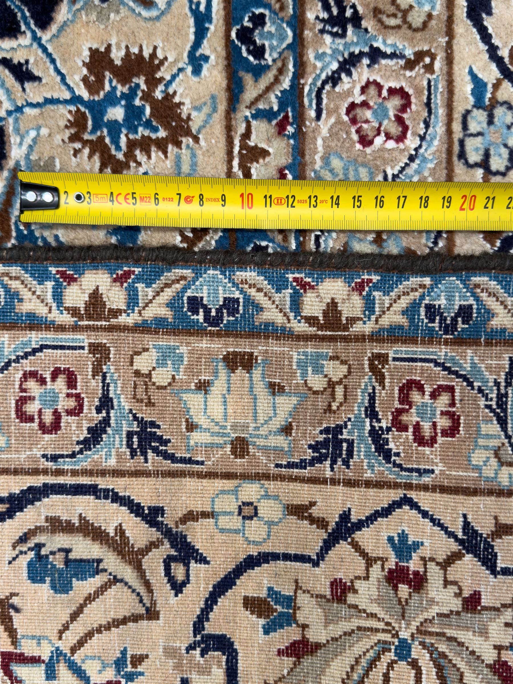 Central Persian Nain carpet, the deep blue field with finely drawn scrolling palmettes and flowering vines around a central ivory and sky blue rosette medallion, enclosed by an ivory border of interlaced floral arabesques and lotus forms between multiple guard stripes, from the region of Nain