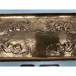 Arts and Crafts Newlyn School copper tray, of rectangular form with rounded corners, with embossed decoration of four stylised fish surrounding a central shaped and vacant panel against a lightly planished ground, stamped Newlyn, L58.5cm, W24.5cm, together with two small Arts and Crafts Newlyn copper pin dishes, the first example of rectangular form decorated with a galleon, L10.5cm, the second of square form decorated with a fish, L8cm, each stamped Newlyn, (3)