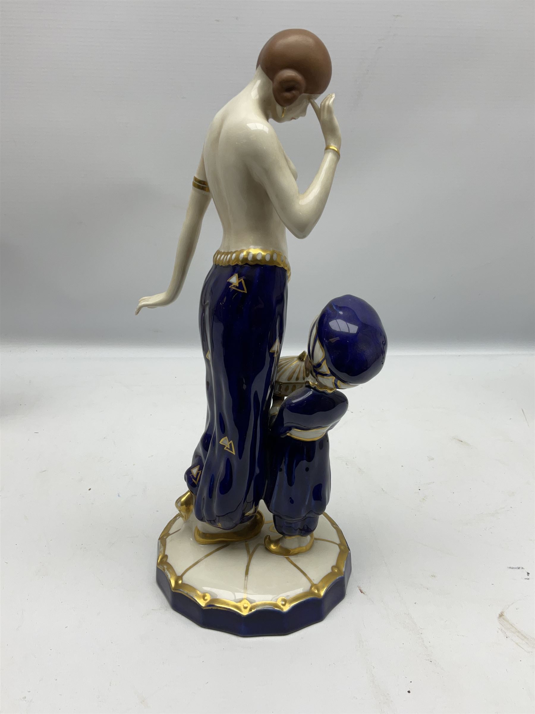 Royal Dux Art Deco figure group of Turkish dancing girl with a young boy beside her holding a casket, decorated with gilding, raised upon scalloped edge plinth base, with applied pink triangle and impressed 2948 beneath