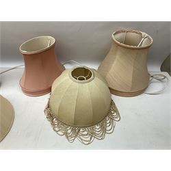 Three white ceramic table lamps, one decorating with fruiting branches, all on turned wood bases, together with a quantity of fabric shades largest H35cm excl fitting