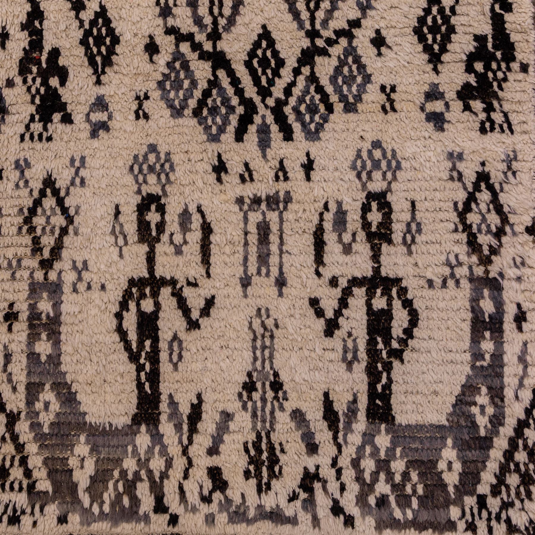 Moroccan hand-knotted Berber rug, of rectangular form, ivory ground woven with horizontal bands of stylized tribal motifs, including abstract animals and anthropomorphic figures, interspersed with geometric devices, with fringe ends 