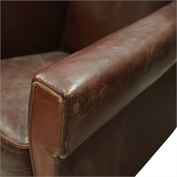 Early to mid 20th century pair of wingback armchairs, upholstered throughout in chocolate brown leather, the backs with deep wings, square padded arms with piped seams, loose seat cushions over solid bases