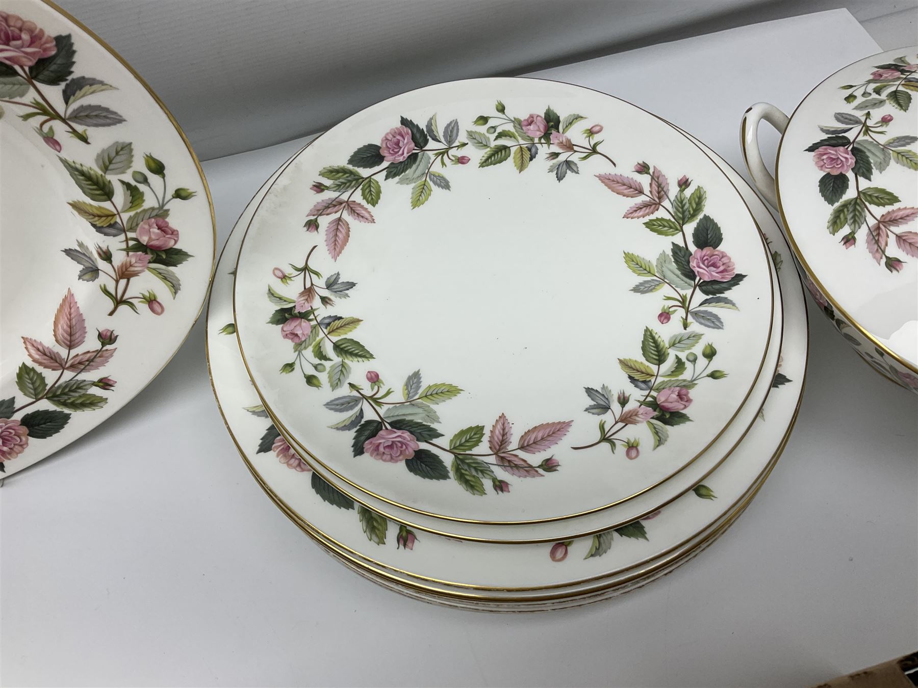 Wedgwood Hathaway Rose pattern tea and dinner wares, comprising twelve saucers, sixteen teacups, twenty tea plates, jug, sucrier, thirteen shallow bowls, sauce boat and saucer, two lidded tureens, larger jug, ten dinner plates, nine smaller plates and two large oval serving dishes