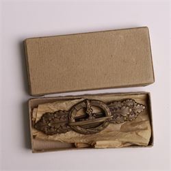 WWII German Kriegsmarine U-Boat combat clasp in bronze by Schwerin Berlin, with the original horizontal pin and catch fixing, makers mark to the reverse “ENTWURF PEEKHAUS AUSF SCHWERIN BERLIN 68” in original packaging