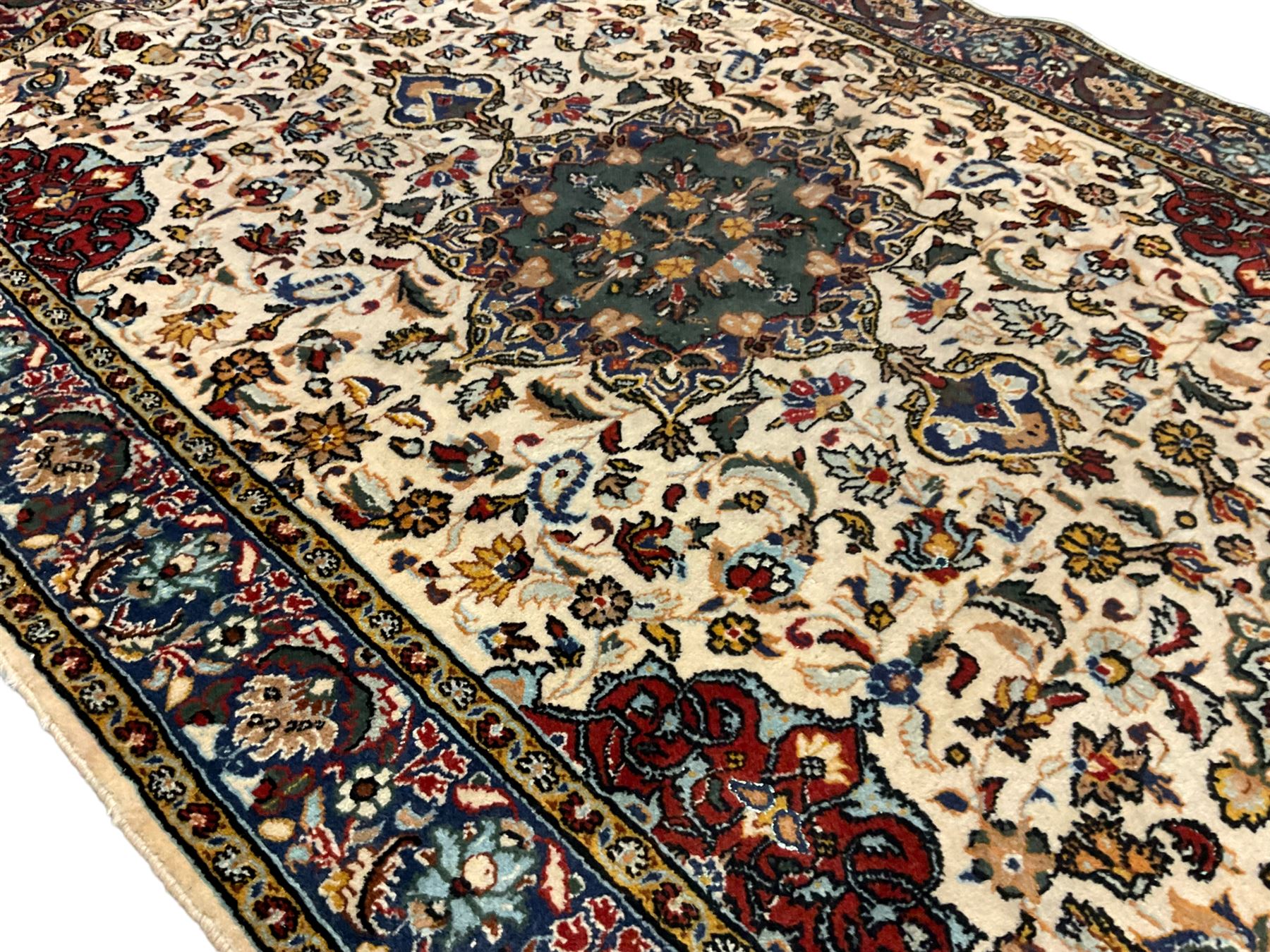 Persian ivory ground rug, central green floral pole medallion within a field decorated by scrolling foliate patterns, the guarded border with repeating palmettes and floral designs
