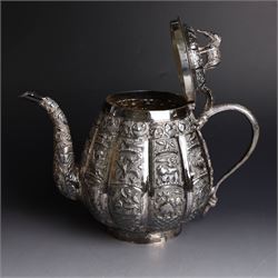Three piece Indian silver tea service, comprising teapot, twin handled open sucrier and cream jug, each with embossed animal decoration with fish border, serpent handles and elephant finial, teapot H17cm