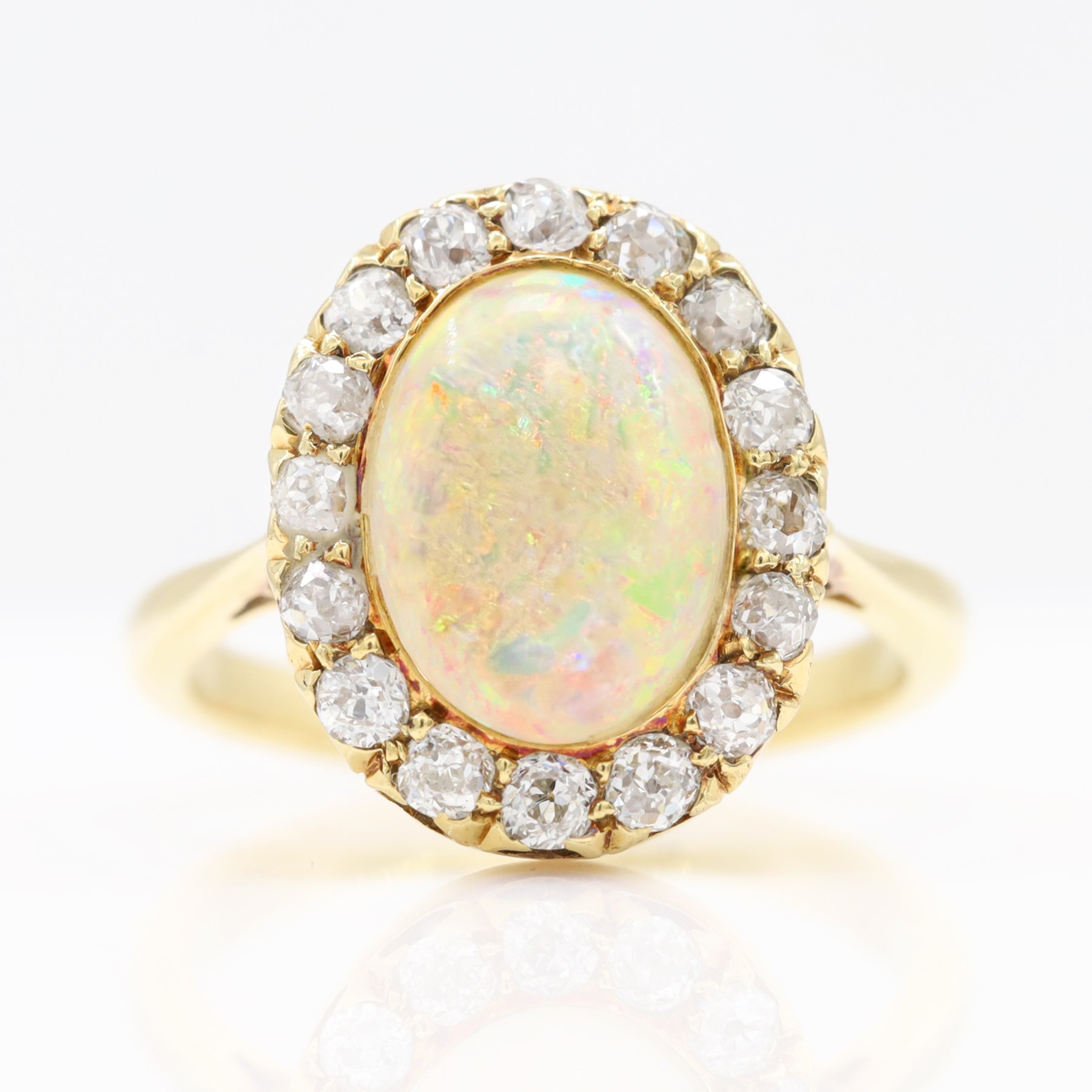 Early 20th century gold opal and diamond cluster ring, single oval cabochon opal, surrounded by sixteen old cut diamonds, stamped 18ct, total diamond weight approx 0.65 carat