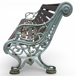 Victorian cast iron garden bench with dark wooden slats and ornate green painted ends.