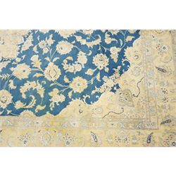 Central Persian Nain hand-knotted rug, sky blue field, with a central cusped medallion in ivory and soft camel tones, issuing an elegant arrangement of scrolling arabesques, palmettes and flowering vines, conforming ivory spandrels, principal pale border decorated with floral sprays and palmettes, flanked by narrow ground borders, with cotton fringe ends  