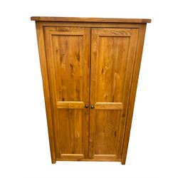 Oak double wardrobe, fitted with two panelled doors enclosing hanging rail