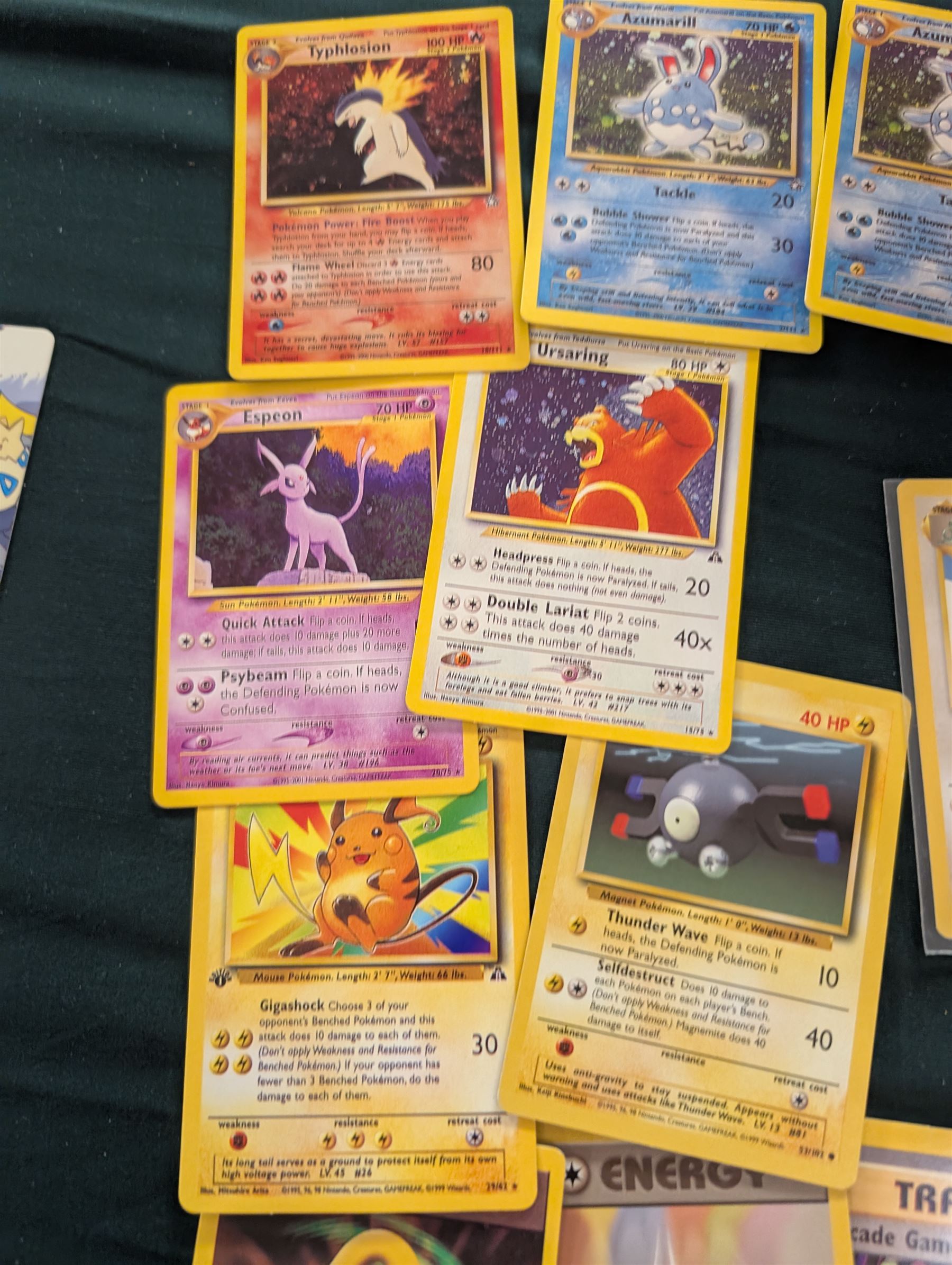 Collection of Pokemon TGC trading cards, including two WB First Movie Black Star promo cards Pikachu no. 4 and Dragonite no. 5, two Ancient Mew Black Star holo promo cards, Gym Challenge Giovanni's Persian 8/132 holo and a small collection WOTC, Neo Discovery and Neo Genesis cards, together with thirty four Bandai Carddass Pokemon cards, including prism Charizard no. 186 and Pokemon Topps cards including holo examples 