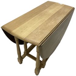 Contemporary oak and beech dining table, oval drop-leaf top on turned supports united by stretchers, gate-leg action base