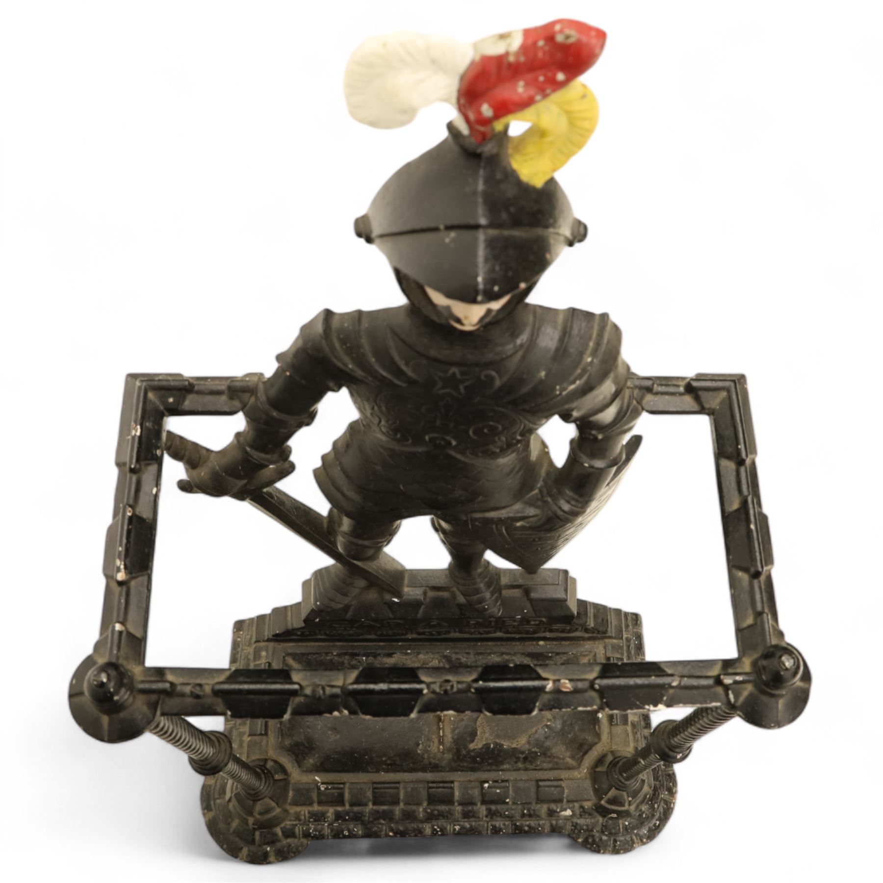 Early 20th century painted cast iron hall stand, formed as a standing armoured figure with red and yellow feathered crest, twin rails and integral drip tray with castellated edge