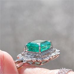 Platinum Colombian emerald and diamond pendant necklace, single octagonal cut emerald of 7.38 carat, surrounded by round cut diamonds in a fancy milgrain pierced design setting, stamped Pt 950, on a trace link chain necklace, total diamond weight 1.14 carat, with GCS certificate