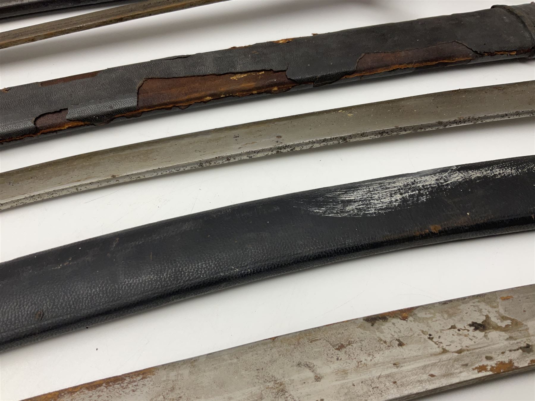 Four Indian tulwar swords; three with cast brass hilts and one with iron hilt; longest blade 81cm; all with scabbards (4)