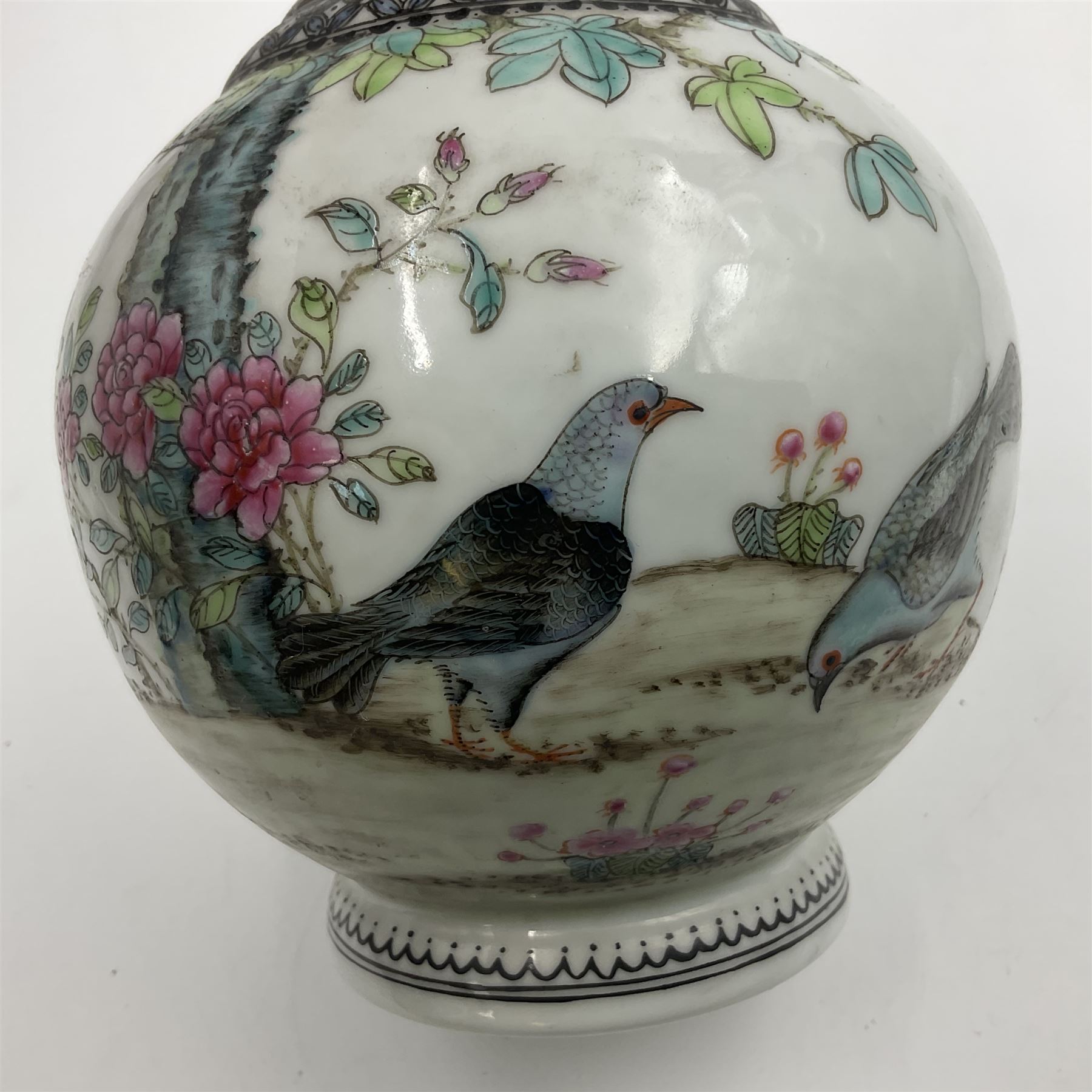 Pair of Chinese Republic porcelain vases, each painted in Famille Rose enamels with pairs of pigeons amidst peony, rock, flowering plants and leafy branches, possibly Qianlong seal beneath, H22cm 
