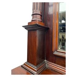 Victorian mirror back press, the arched corniced mirror back flanked by half columns, the base fitted with three drawers and four moulded panel doors with geometric detail, on a block plinth