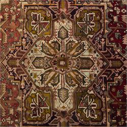 Northwestern Persian Heriz carpet, crimson ground and soft green field, with bold terracotta stepped medallion with angular spandrels and geometric motifs within a broad palmette and vine border 