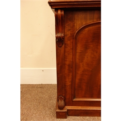  Victorian mahogany bookcase on cupboard, projecting cornice above two arched glazed doors, carved scrolled corbels, the base with panelled cupboard on a skirted base, W141cm, H227cm, D55cm  