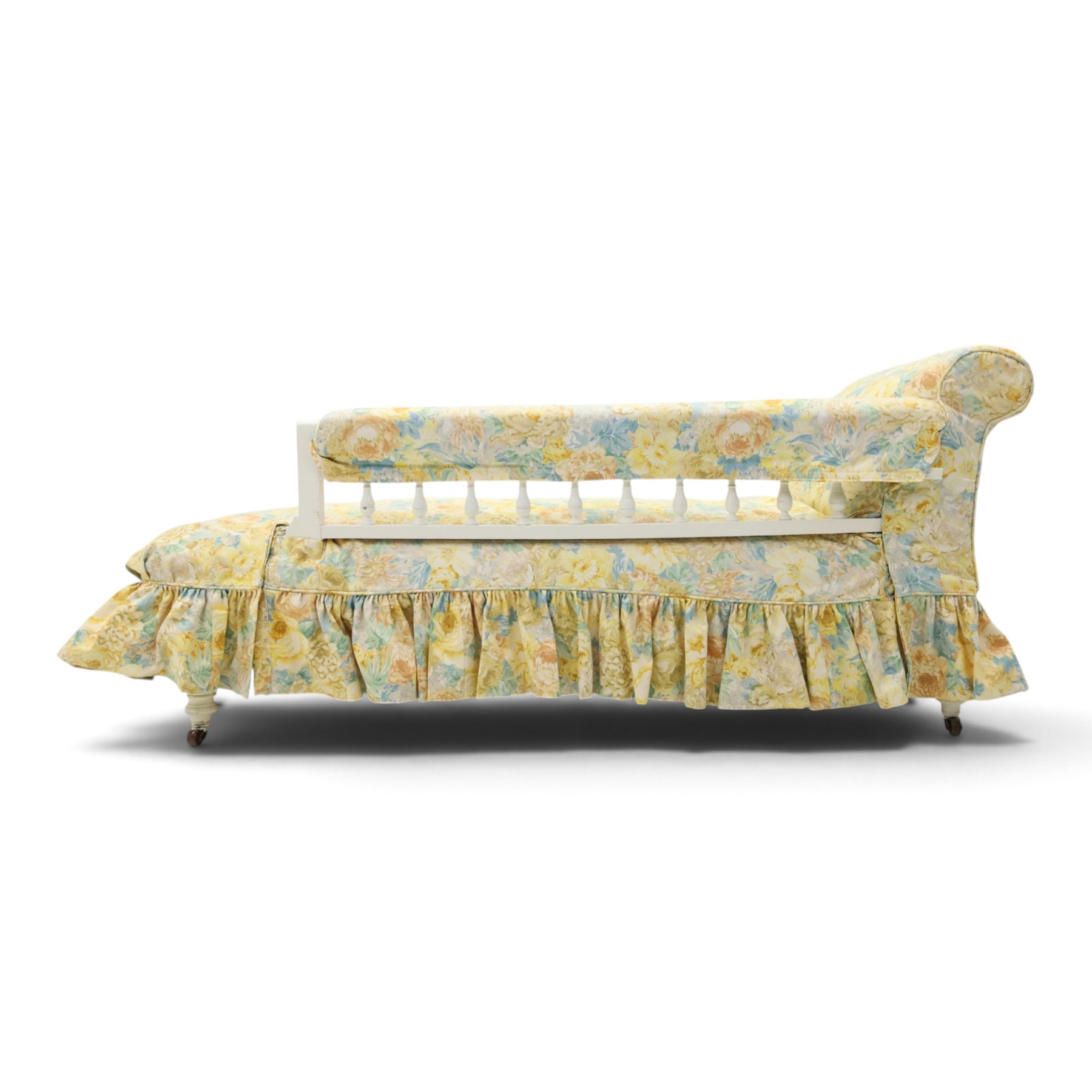 Victorian chaise longue in chintz upholstery, scrolled back with turned spindles up, raised on castors
