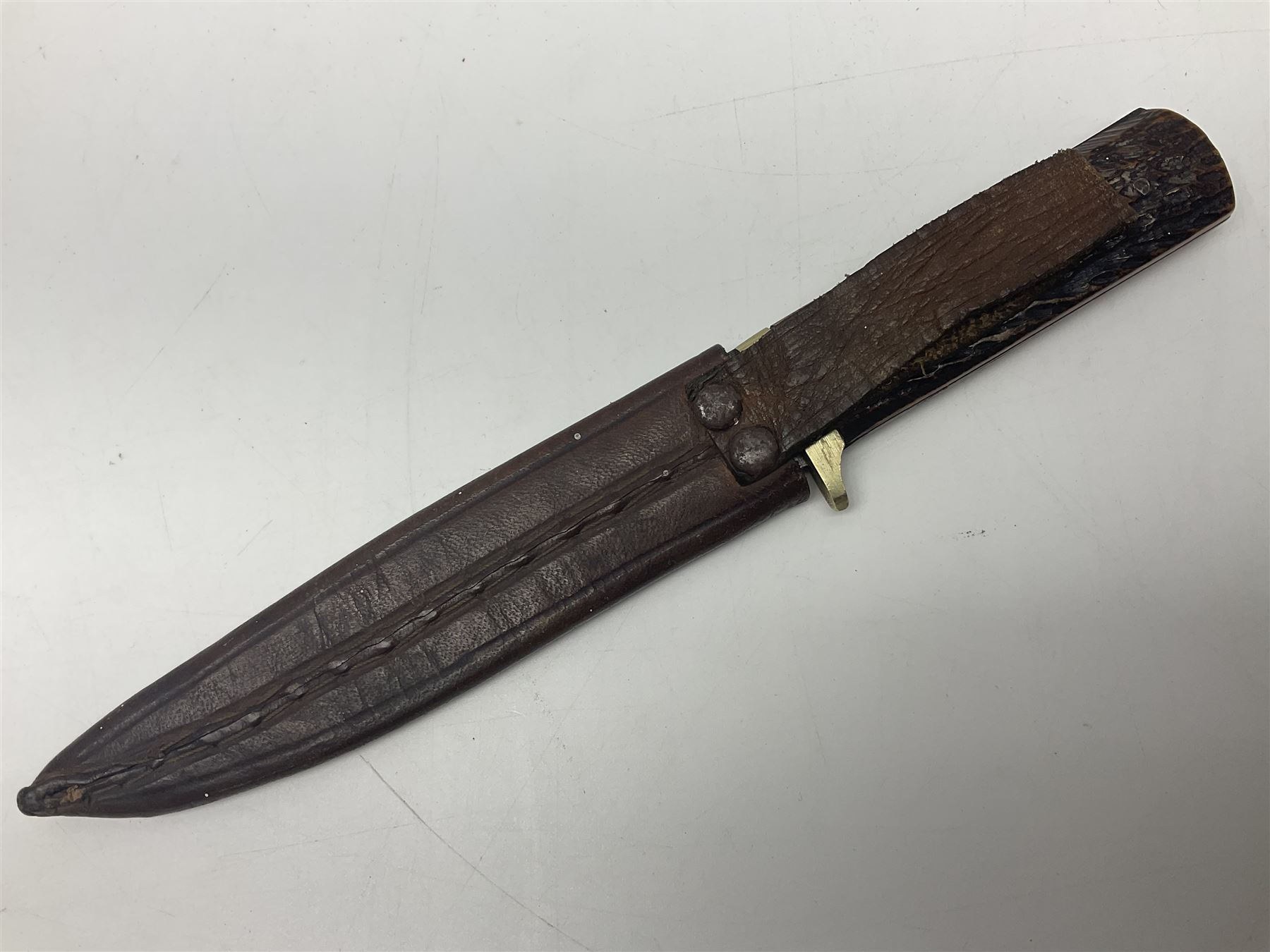 WW2 fighting knife, the 13cm blade by Priestman of Sheffield marked with scout and camp fire motif; two piece antler grip; in leather sheath crudely marked R.T. with a broad arrow L23cm overall Auctioneers Note: By family descent this knife was reputedly presented to Richard Towse during WW2 for guarding a group of POWs.