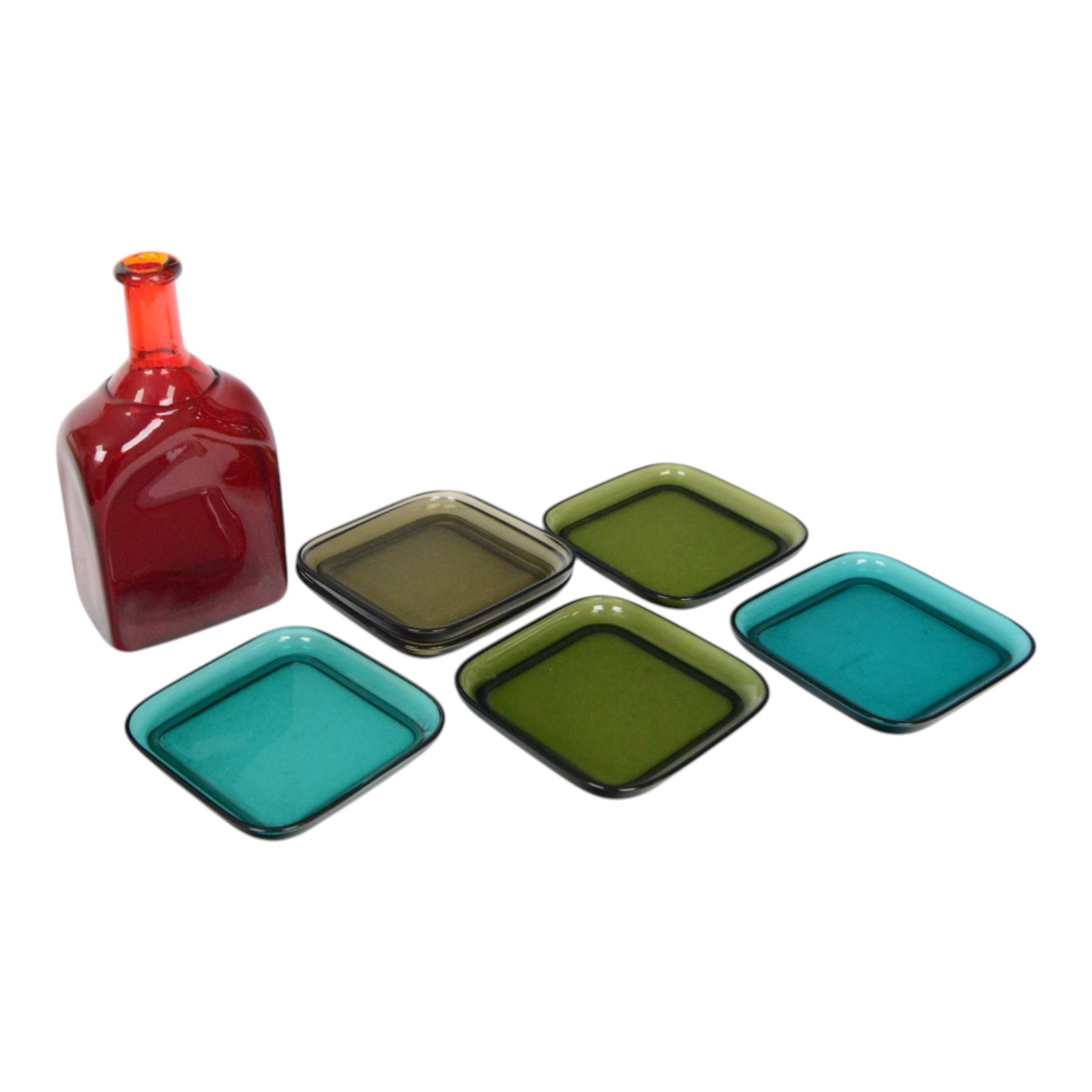 Mid century Finnish red glass bottle, designed by Nanny Still for Riihimaen Lasi, of square sided form with tall neck, H21.5cm, together with set of six mid century Finnish glass plates, designed by Kaj Franck, in smokey green, olive green and turquoise green, 13.5cm x 13.5cm
