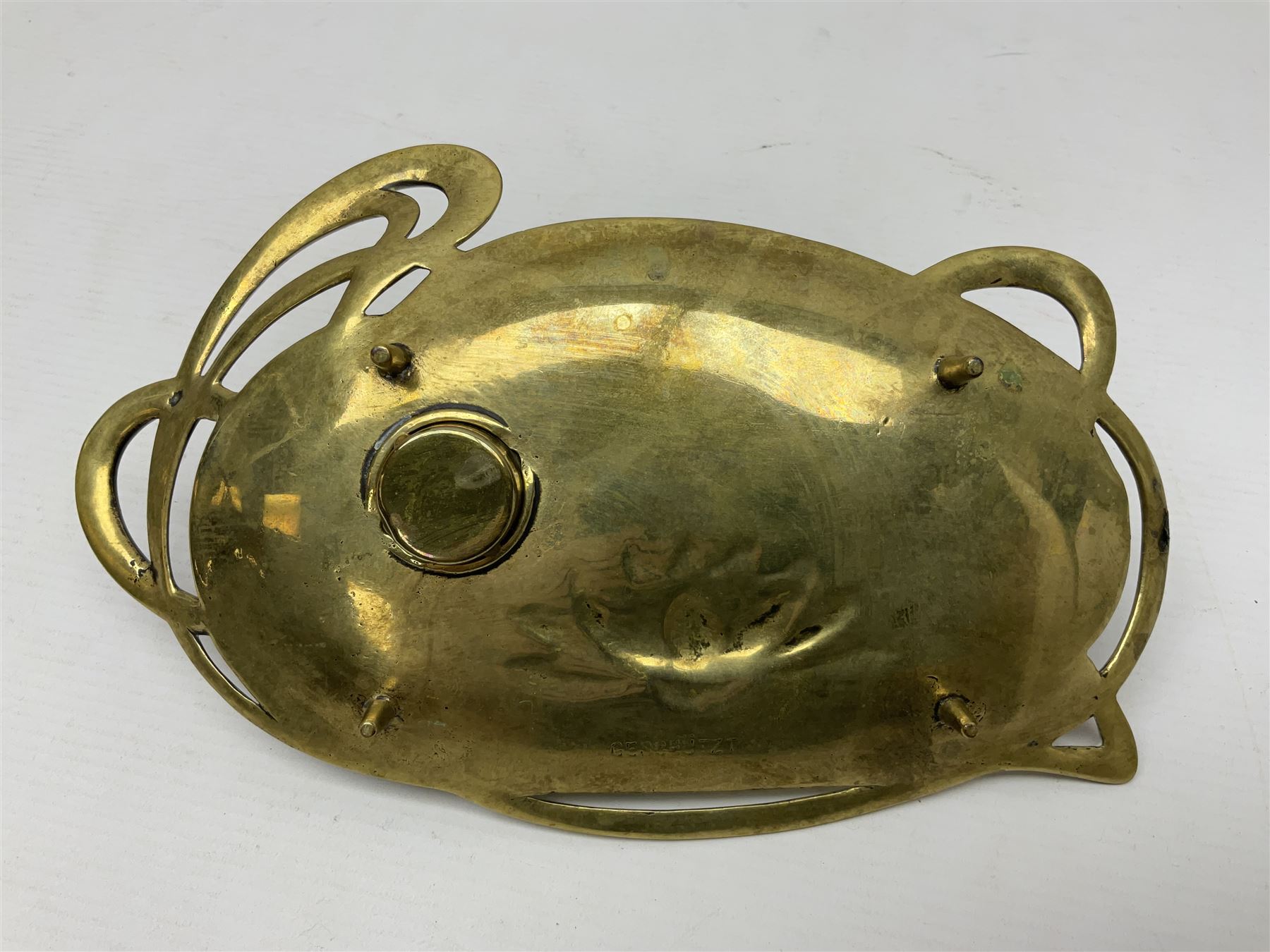 Art Nouveau Geschutzt brass desk stand, with stylised whiplash relief decoration, with removable Loetz style green glass inkwell, stamped to the base, H8cm