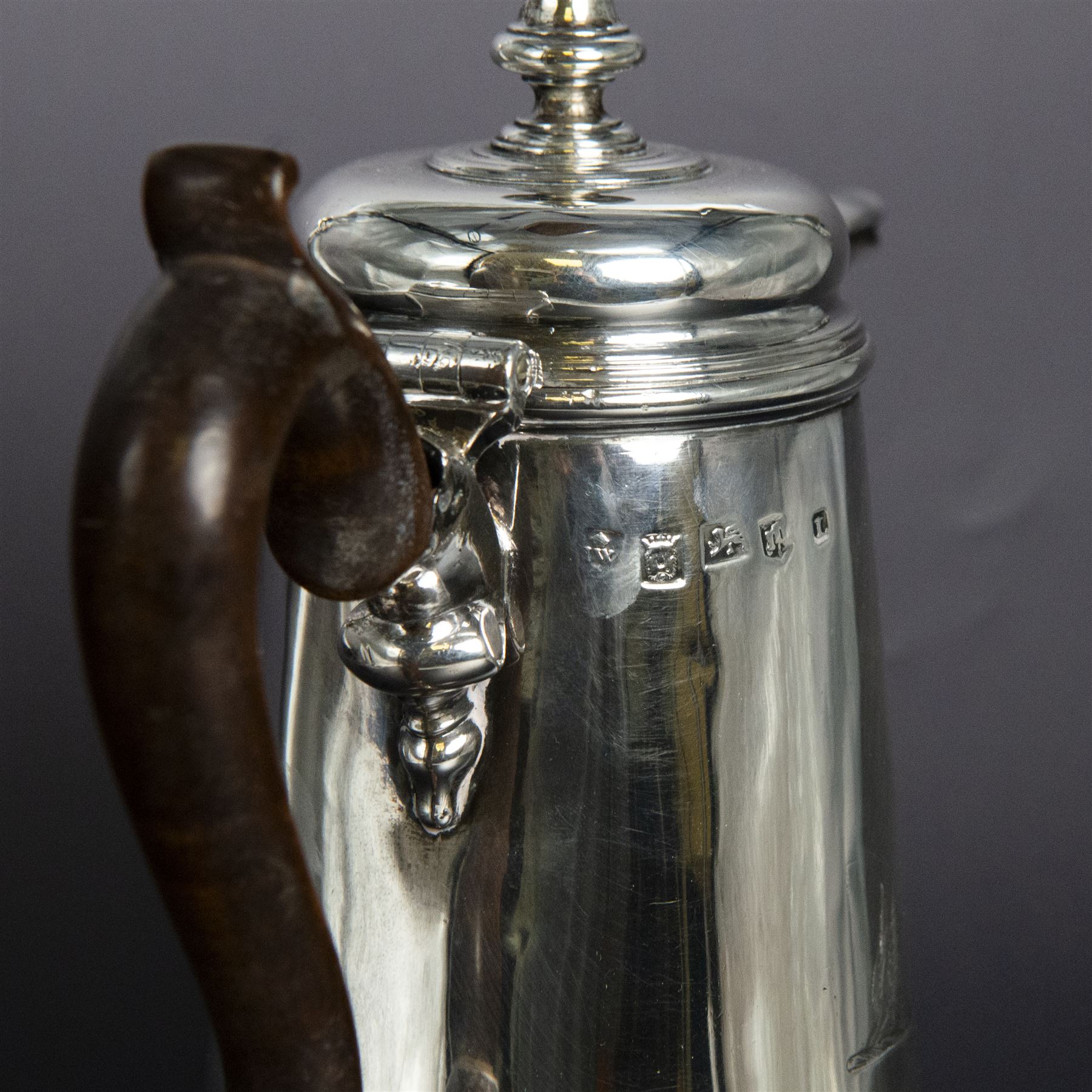 George II provincial silver coffee pot, of tapering cylindrical form, with wooden scroll capped handle, hinged cover with bell finial, and engraved crest to body, hallmarked John Webber of Plymouth, Exeter 1759, H21cm