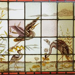 Large Victorian Aesthetic movement stained glass leadlight window panel, hand painted with a scene of herons and other birds in a lake, overall 82cm x 147cm 