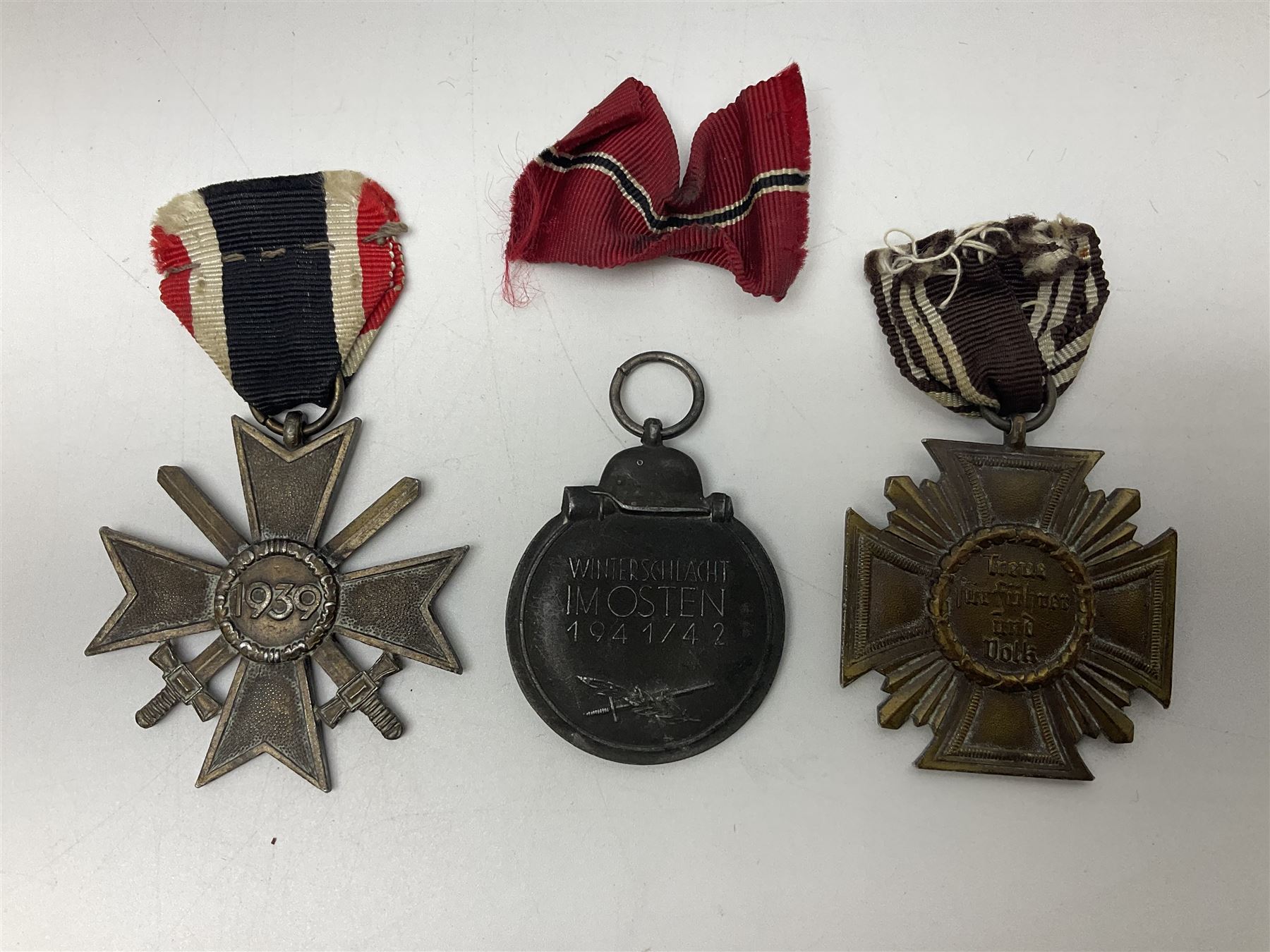 WW2 German Eastern Front Medal awarded to those who served on the German Eastern/Russian Front during the Winter Campaign period of 15th November 1941 to 15th April 1942 with original ribbon; German War Merit Cross with swords; and NSDAP Long Service Award (3)