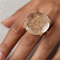 18ct gold rock crystal ring, single round cut crystal, mounted in a fancy textured swirl under setting, stamped 750