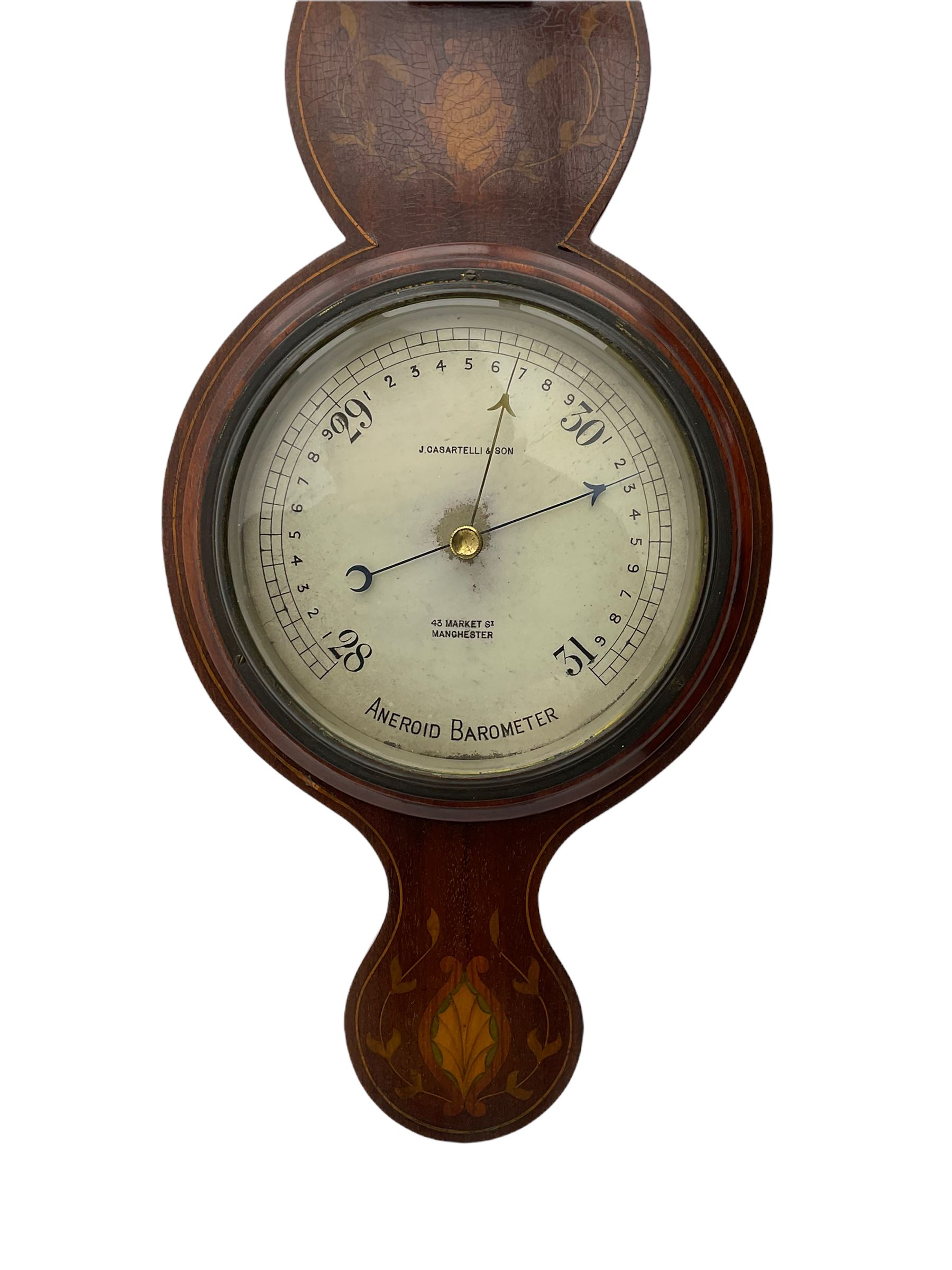 A compact Edwardian Aneroid barometer in a  Regency “Sheraton style”case, broken pediment with finial and rounded base, mahogany veneered with satinwood stringing to the edge and panels of coloured and shaded conch shell and leaf inlay enclosed within entwined leaves, with a six inch dial recording barometric air pressure from 28 to 31 inches in fifths of an inch, steel indicating hand and brass recording hand, dial inscribed “J Casartelli & Son, 43 Market Street, Manchester”, with a flat bevelled glass and brass bezel, glazed arched topped thermometer box with a spirit thermometer and silvered register recording the temperature in degrees Fahrenheit.
*J Carsatelli & Son (1896-1925) A partnership between Joseph Lewis and his son Joseph Henry. The elder Joseph died in 1900 and the son carried on the business until his death in 1925.  
