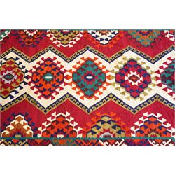 Persian Qashqai crimson ground rug, the central narrow ivory field decorated with repeating hooked geometric lozenges in multicolours, with a densely decorated guard band