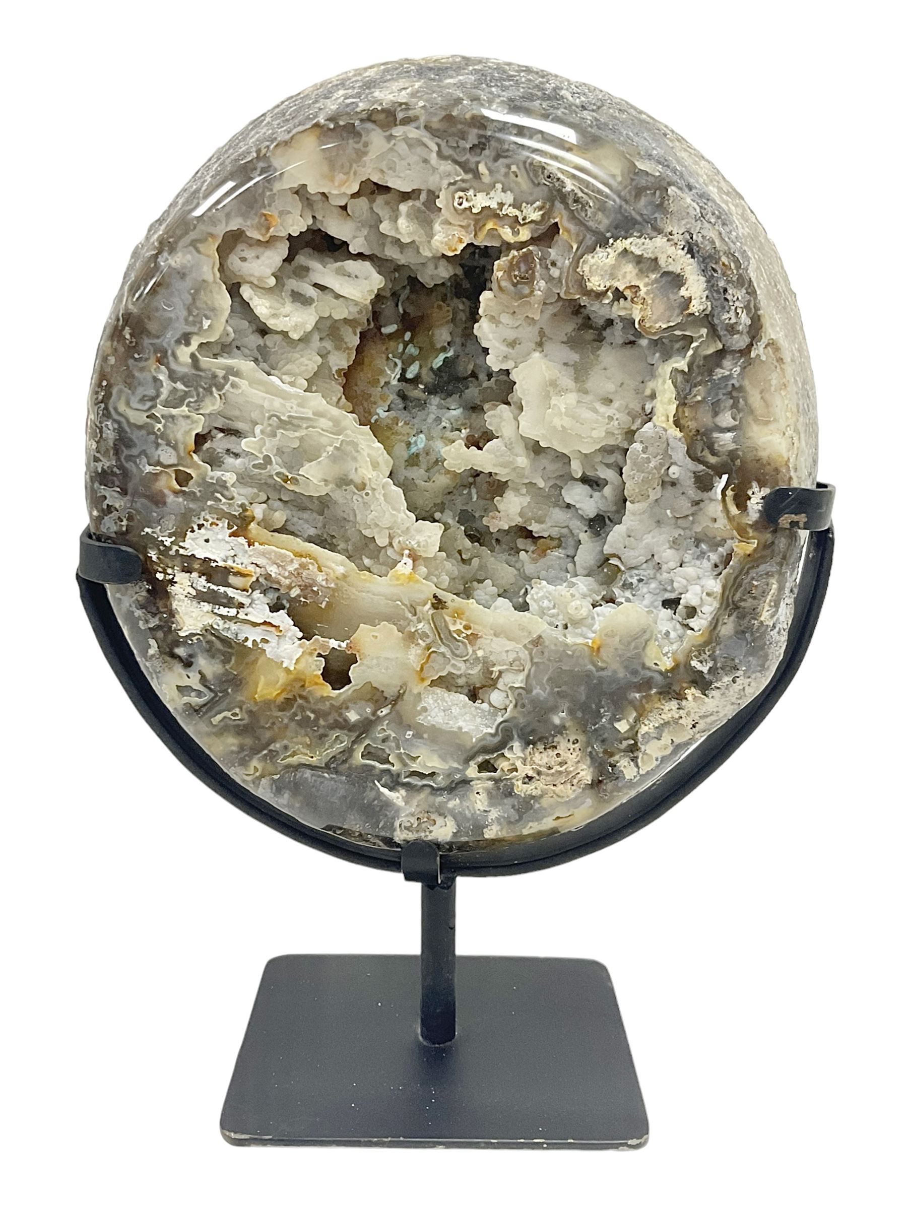 Large agate geode with quartz crystals to the centre, upon a metal stand, H35cm 