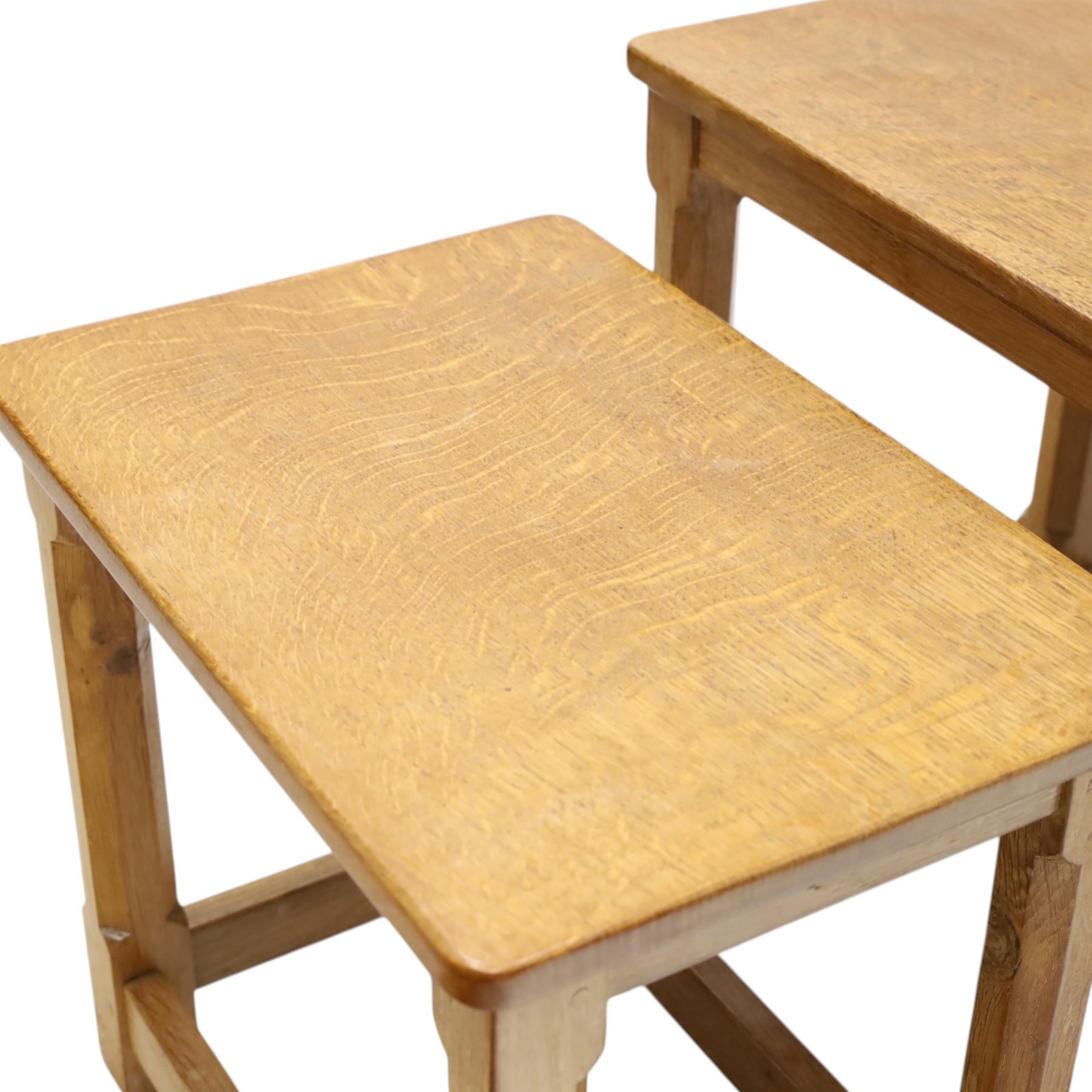 Mouseman - set of three adzed light oak nesting tables, each with rectangular top raised on octagonal legs joined by stretchers, with signature carved mouse, by the workshop of Robert Thompson, Kilburn