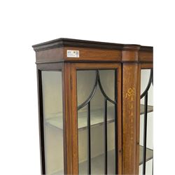 Edwardian inlaid mahogany display cabinet, enclosed by two astragal glazed doors, bowed centre inlaid with ribbon and trailing bellflowers, on square tapering supports with spade feet united by undertier 