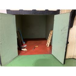 Large Tri-ang No.93 doll`s house in the 'Stockbroker's Range' c1935; two-storey double-fronted Tudor design, half timbered gables, two-storey bay windows, cream and mock shrubbery to front, opening metal framed windows with green shutters, red simulated tiled roof with chimney, integral garage with opening doors, front elevation has four hinged doors opening to reveal two bedrooms with fire places, living room, bathroom and kitchen with built in dresser and sink, entrance hall and staircase, side entrance with porch and seat and sun dial over on chimney stack; some wiring for electrical lighting; metal Tri-ang Toys disc verso; comprehensively furnished H66cm L117cm D43cm