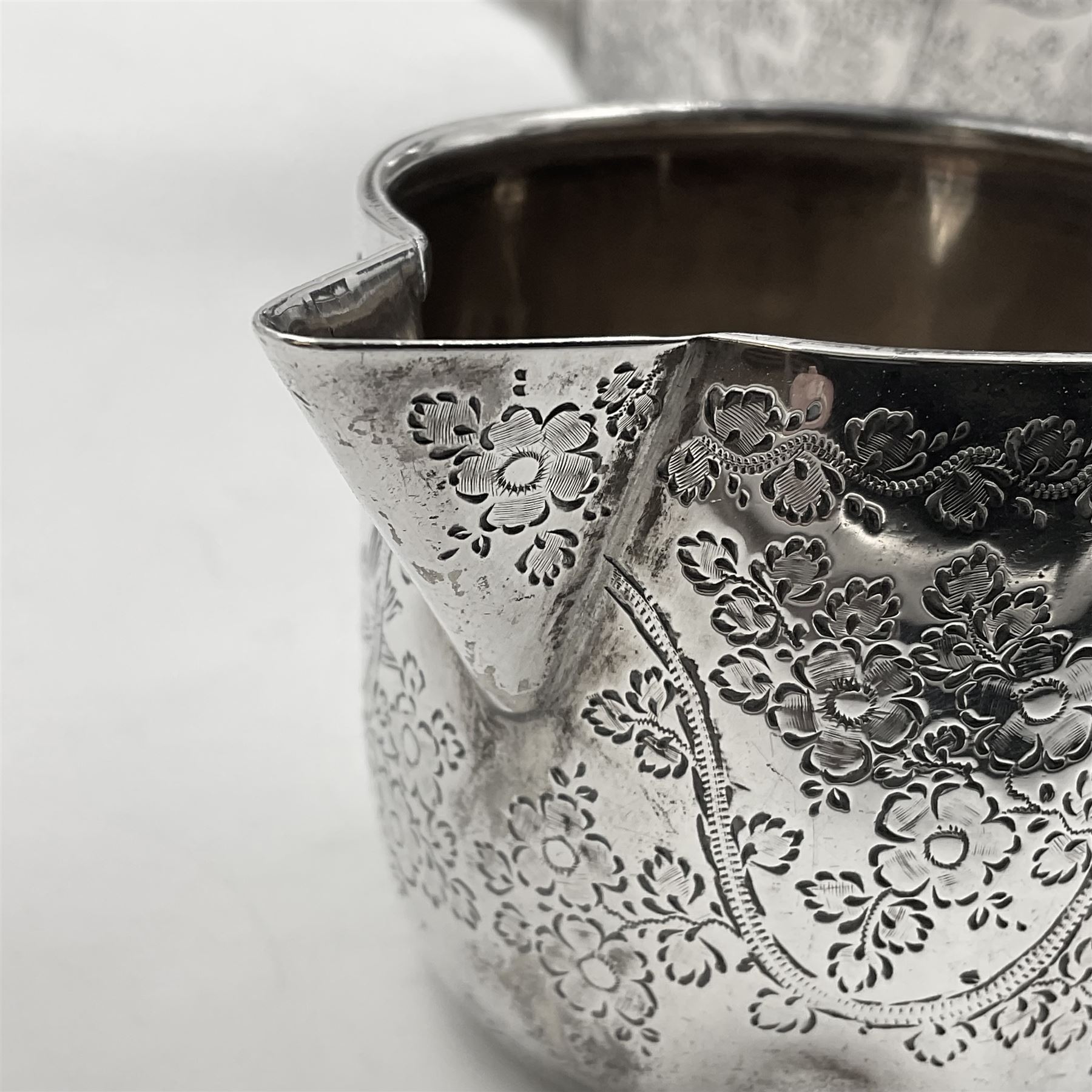 Late Victorian silver bachelors three piece tea service, comprising bullet shaped teapot, open sucrier and milk jug, each engraved with monogram surrounded by birds upon and amidst a blossoming vine, the teapot with scroll capped curved wooden handle and wooden finial to cover, hallmarked Wakely & Wheeler, London 1890, teapot including handle H12cm, sucrier H5.5cm 