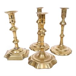 pair of 18th century brass candlesticks, each having slender knopped stems and scalloped petal base, together with two other brass candlesticks, H21cm