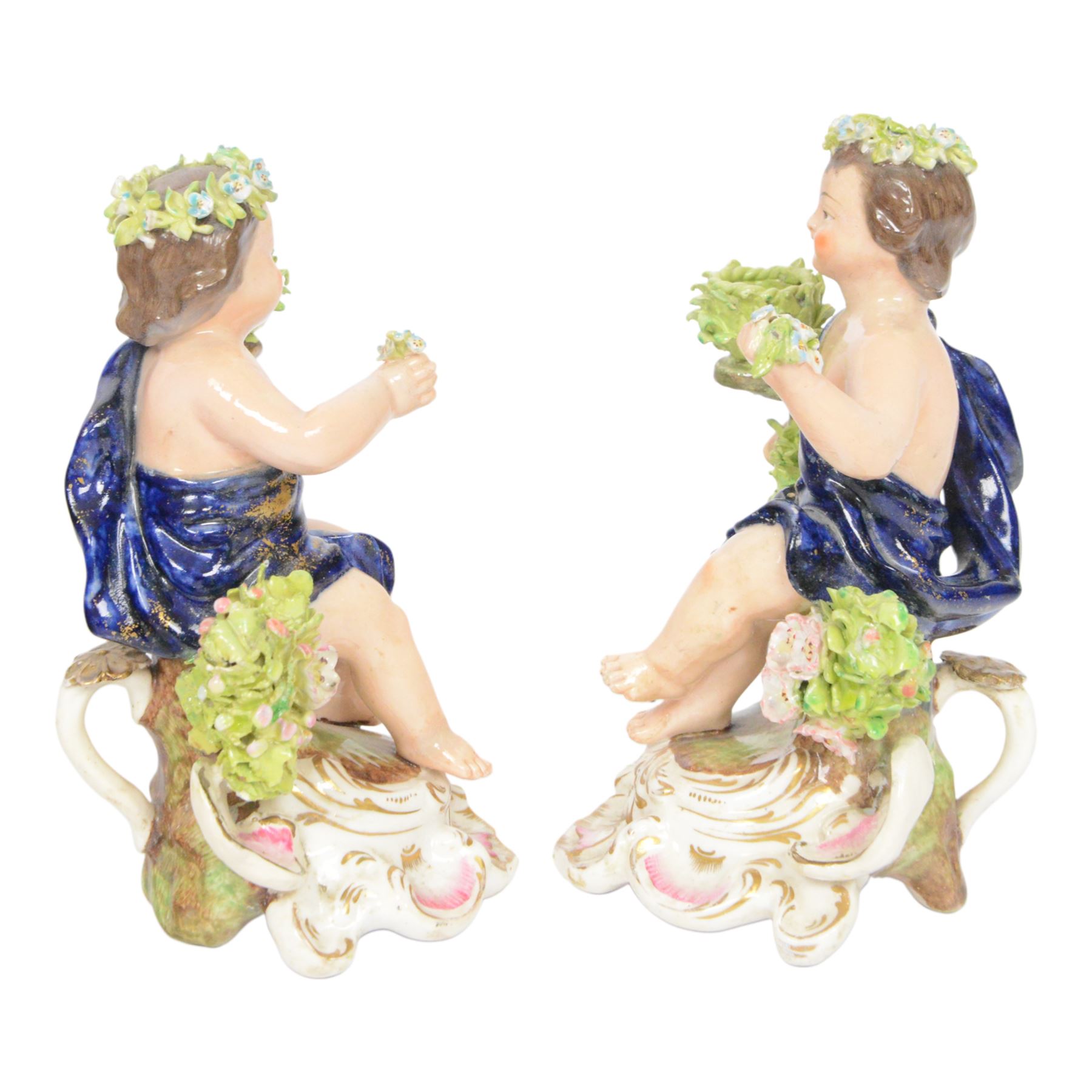Pair of 19th century Stevenson and Hancock Derby figural chambersticks, each modelled as a seated cherub with arm around foliate encrusted sconce, marked beneath, H18cm