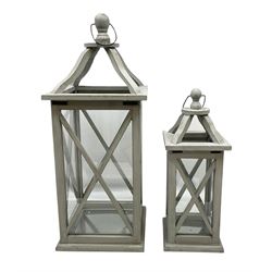 Two wooden lanterns with four glass sides, loop handles and open tops, largest example 58cm