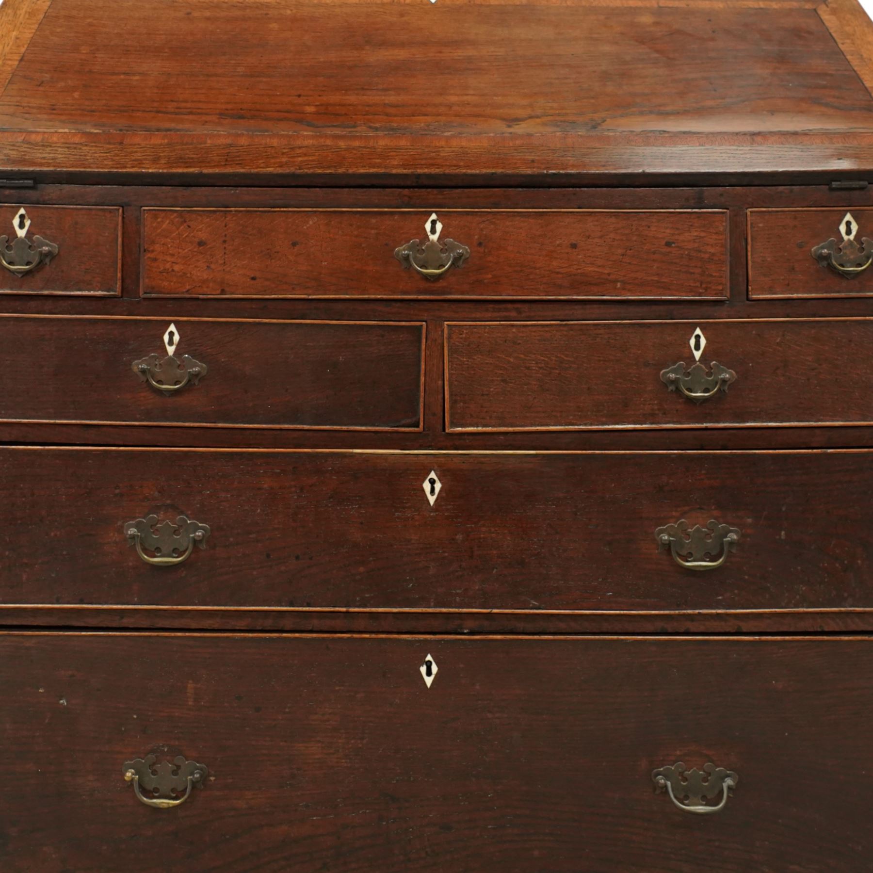 George III oak bureau, the fall front enclosing a fitted interior of small drawers and pigeonholes, above seven graduated drawers with brass plate handles and bone escutcheons, raised on bracket feet