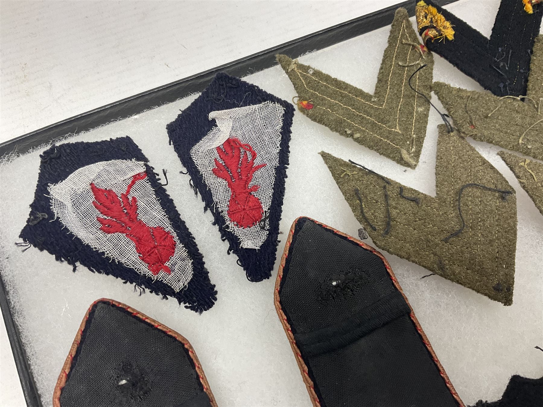 Over thirty items of French Sapeur Pompiers (Fire Service) cloth insignia and buttons c1930s/40s; in small glazed display case