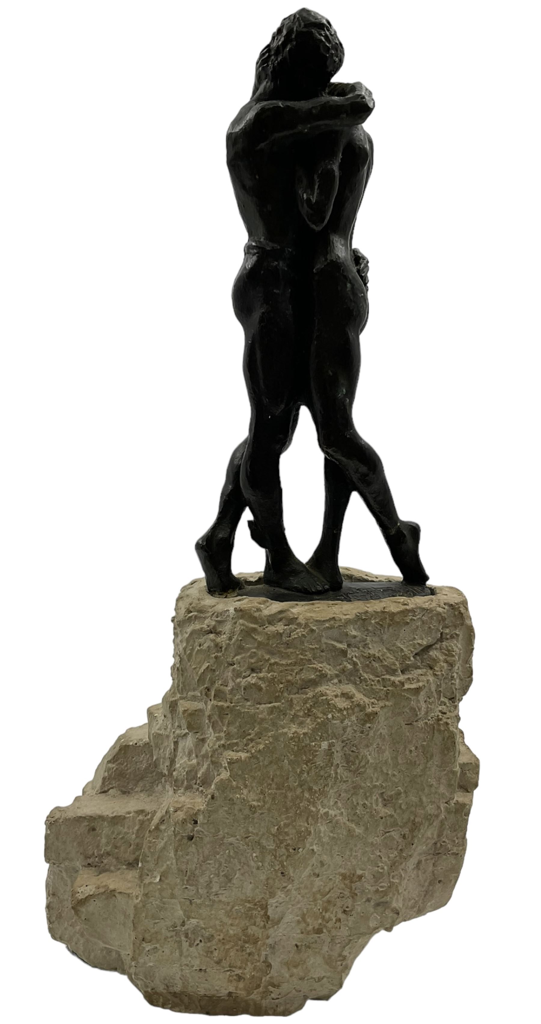 Composite sculpture embracing couple, after Joseph Bofill on a rocky base, height 33cm.