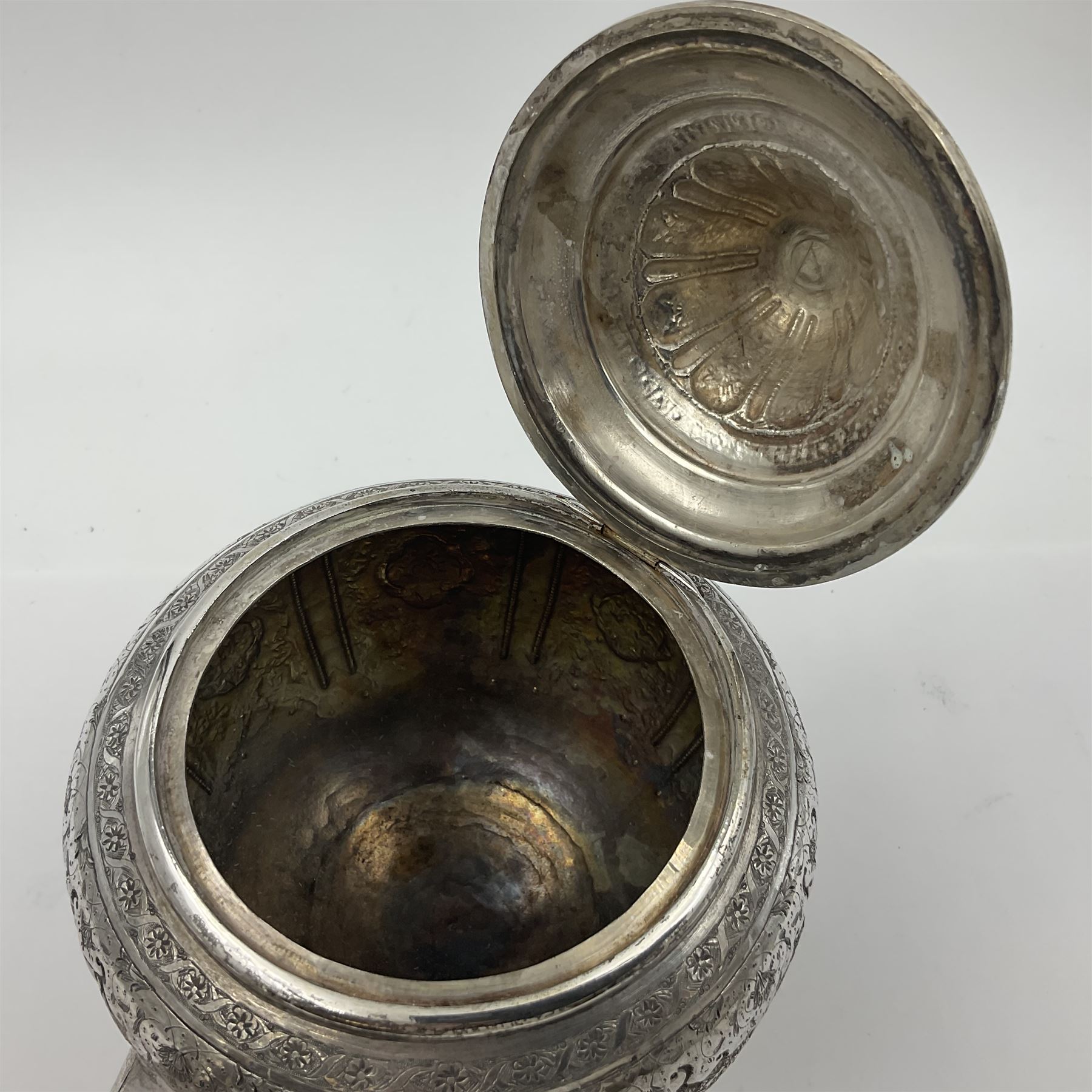 Early/mid 20th century Persian silver tea service, comprising circular serving tray, teapot, twin handled sucrier and cover, milk jug, five tea glasses with six silver holders, six tea spoons, and pair of sugar tongs, each profusely chased with foliate arabesque decoration, each bearing marks including 84 for 840 fineness, tray D40cm, teapot H16cm