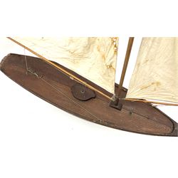 Large Victorian pond yacht, the planked hardwood hull with large lead weighted keel and working rudder, simulated planked deck and single mast with original sails; on later scratch-built wooden stand L117cm H151cm