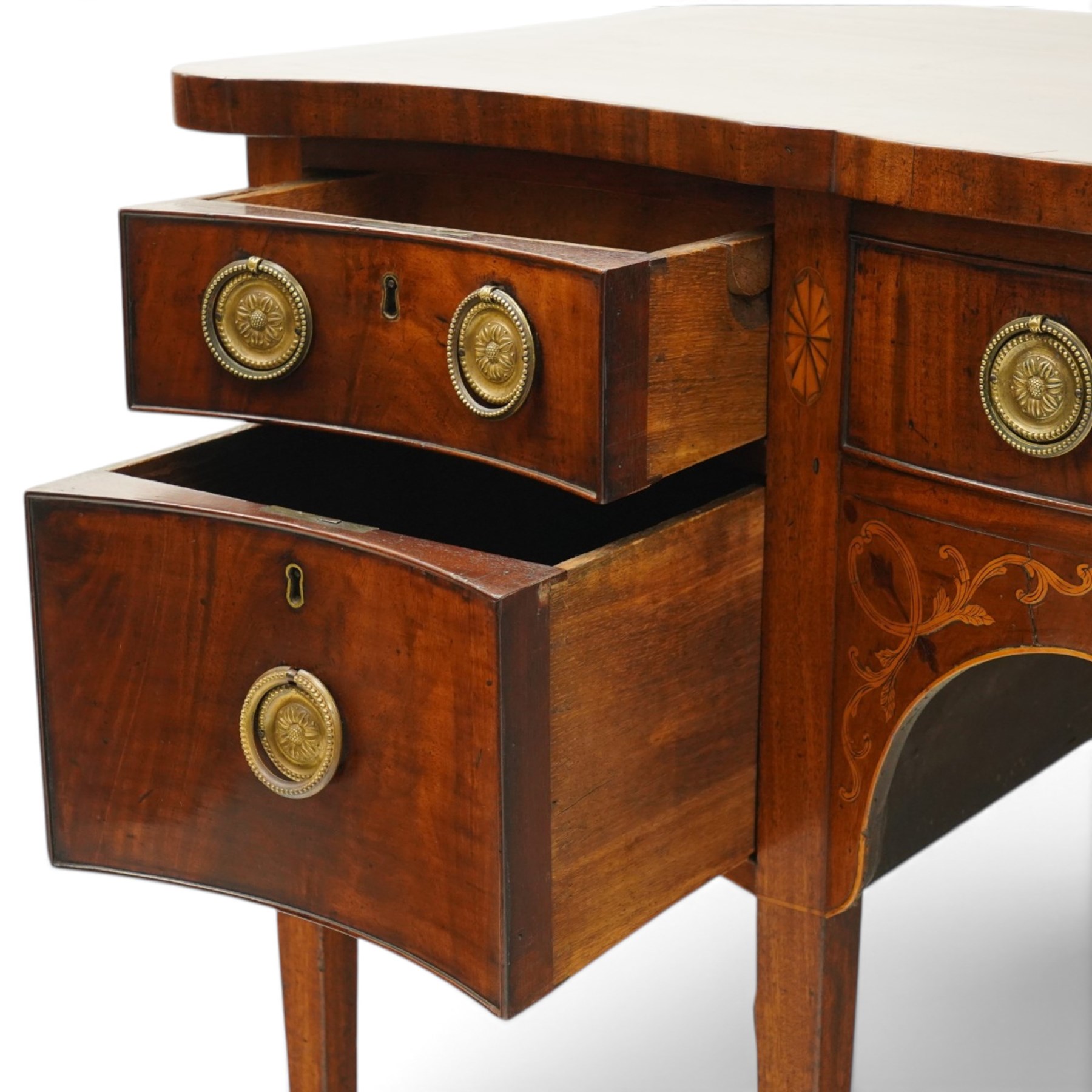 George III inlaid mahogany serpentine sideboard, the shaped top with crossbanding and satinwood stringing, fitted with central bow-front cock-beaded frieze drawer over a shaped apron inlaid with paterae, shell motifs and scrolling foliage, flanked by a deep right-hand drawer and two drawers to the left, raised on square tapering supports with spade feet