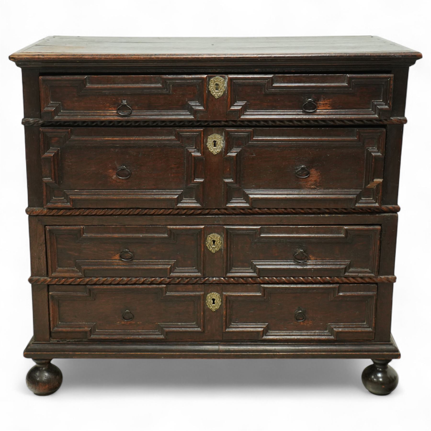 Late 17th-century oak chest, rectangular top above four graduated drawers with geometric panel mouldings, in two sections, supported on bun feet 